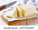 Sliced pieces of butter on a light table, selective focus. Piece of butter.