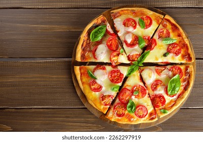 Sliced pizza Margarita over wooden background. Top view, flat lay - Powered by Shutterstock