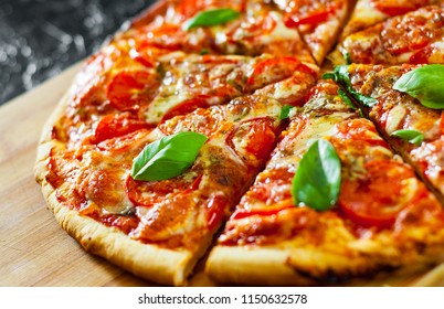 Pizza in Scheiben mit Mozzarella-Käse, Tomaten, Pfeffer, Gewürze und Basilikum. Italienische Pizza. Pizza Margherita oder Margarita