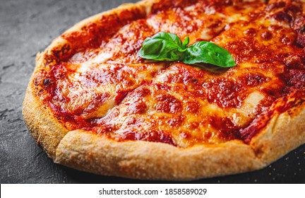 Sliced Pizza With Mozzarella Cheese, Tomatoes, Pepper, Spices. Italian Pizza. Pizza Margherita Or Margarita On Dark Grey Black Slate Background