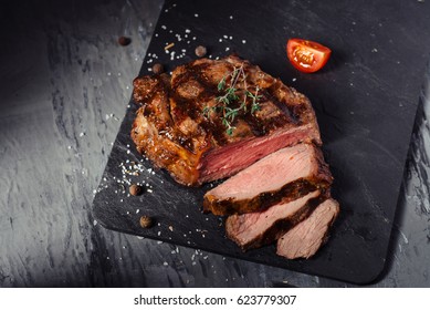 Sliced pork Steak and tomatoes on the slate Board - Shutterstock ID 623779307
