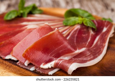 Sliced Prosciutto On A Wooden Table