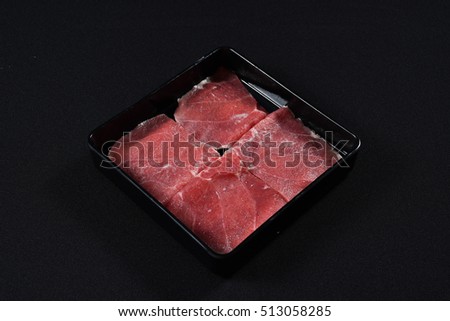 Sliced raw beef sirloin on a black plate