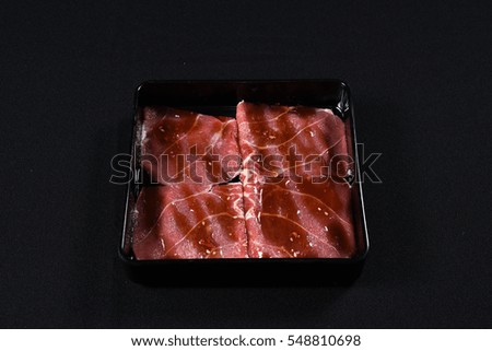 Sliced raw beef sirloin on a black plate