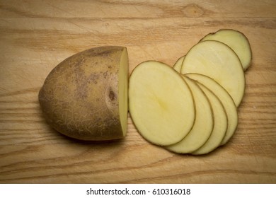 Sliced Raw Potato On Wooden Board