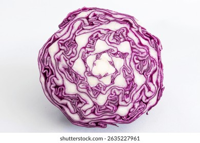 A sliced of red cabbage isolated. Close up view of an intricate pattern of purple color cabbage. Fresh vegetable cross section