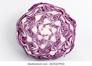 A sliced of red cabbage isolated. Close up view of an intricate pattern of purple color cabbage. Fresh vegetable cross section