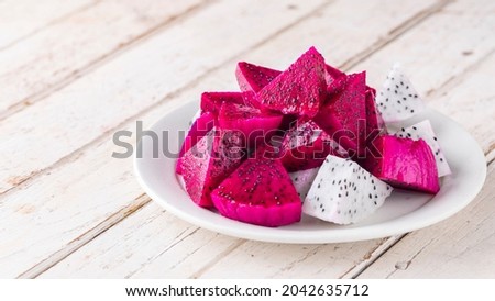 sliced red dragon fruit, Costa Rican dragon fruit, purple pitaya, strawberry pear cactus and white dragon fruit in white ceramic plate on white old wood texture background with copy space, pitahaya