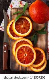 Sliced ripe Sicilian orange on an old cutting board.
