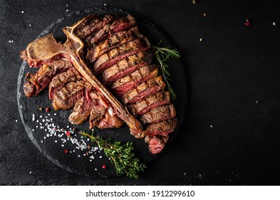 Sliced And Roast T-bone Or Porterhouse Beef Meat Steak For Steakhouse Menu On Black Background. Menu Recipe Place For Text, Top View.