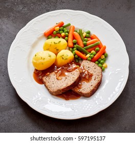 Sliced Roasted Meat Loaf And Gravy With Baby Boiled Potatoes And Mixed Fresh Vegetables Served On A Plate In Square Format