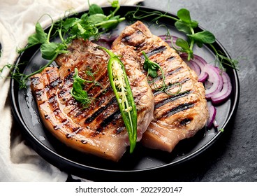Sliced roasted pork meat on dark gray background. Organic gourmet food concept. 