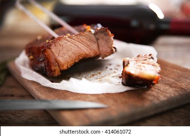 Sliced Roasted Pork Steak With Meat Fork And Knife On Wooden Background