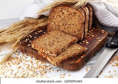 Sliced rye bread on cutting board. Whole grain rye bread with seeds on rustic background