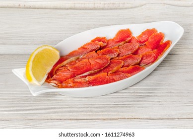 Sliced Sockeye Salmon On A White Plate With Lemon