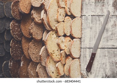 Sliced sorts of bread gradient background. Bakery and grocery concept with knife. Black, rye and white loaves