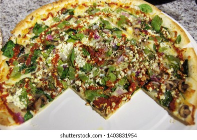 Sliced Spinach Cottage Cheese Pizza With Red Sauce Swirl Cut In Geometric Shapes Facing Downward