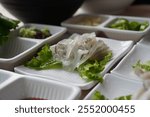 Sliced squid on lettuce leaf in white plate on wooden table