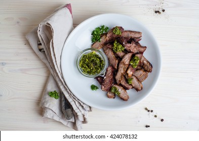 Sliced Steak Served In White Bowl With Chimichurri Sauce. Top View.