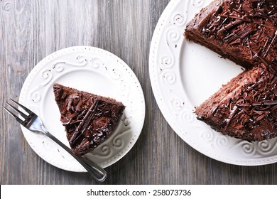 Sliced tasty chocolate cake on wooden table background - Shutterstock ID 258073736