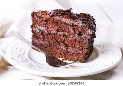 Sliced tasty chocolate cake in plate on wooden table, closeup - Shutterstock ID 268599146