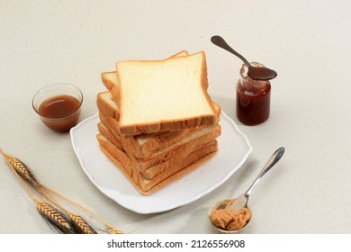 Sliced Toast Loaf White Bread (Shokupan or Roti Tawar) for Breakfast on Wooden Background, Served with Jam and Peanut Butter. Bakery Concept Picture