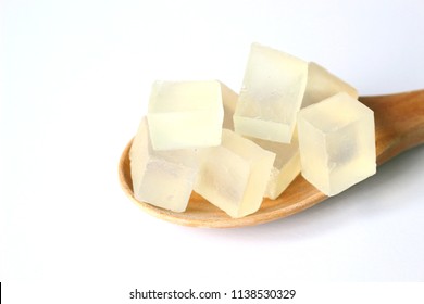Sliced transparent melt and pour glycerin soap bases, material for homemade soap, on wooden paddle on white background.
