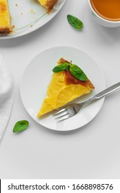 Sliced Upside Down Pineapple Cake Decorated Green Leaves With Cup Of Tea On White Table. Summer Tropical Dessert. Top View. Copy Space