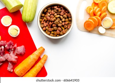 sliced vegetables and petfood on kitchen table background top view mock up