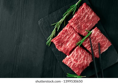 Sliced Wagyu Marbled Beef For Yakiniku On Plate On Black Background, Premium Japanese Meat And Stick, Top View And Copy Space