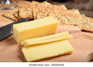 Sliced White Cheddar Cheese On A Cutting Board