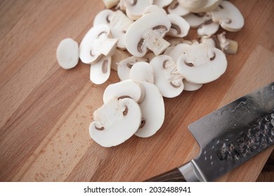 Sliced White Mushrooms On A Wooden Cutting Board.