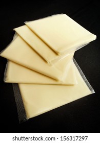 Slices Of American Cheese On Black Background