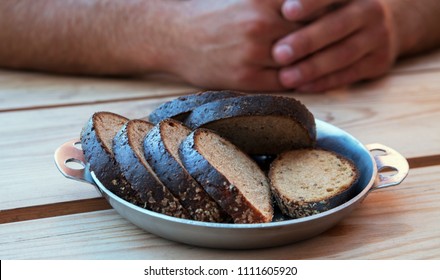 Slices of black bread on table and hands.