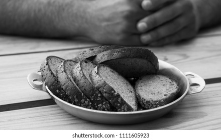Slices of black bread on table and hands.