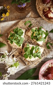 Slices of bread with leftover Easter eggs and fresh wild garlic leaves, top view