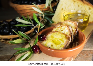 Slices Of Bread In A Plate Of Terracotta Covered By Extra Virgin Olive Oil From Puglia, Salento, Italy. Tradicional Starters Of Mediterranean Diet. Healthy Organic Food