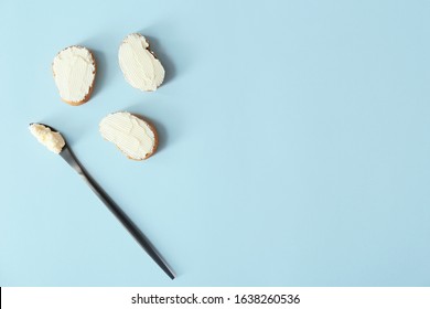 Slices Of Bread With Tasty Cream Cheese And Knife On Color Background