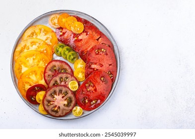 Slices of bright colorful  tomatoes on plate, overhead horizontal shot - Powered by Shutterstock