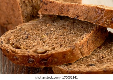 Slices Of Brown Bread On A Wooden Table