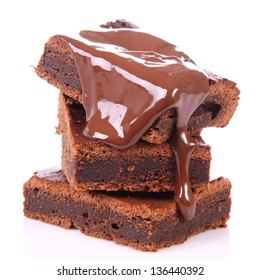 Slices of a brownie on white background covered with chocolate