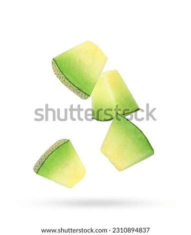 Slices of cantaloupe melon falling in the air isolated on white background.