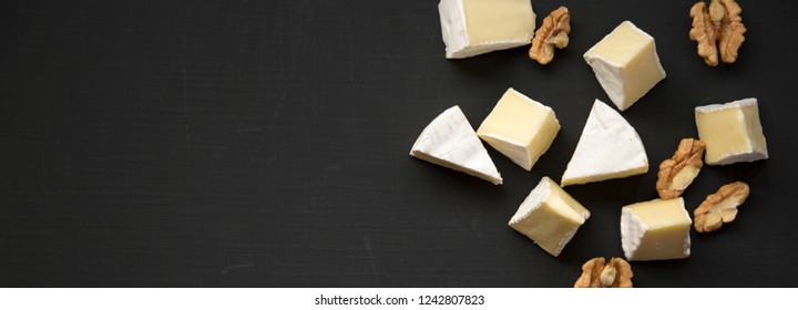 Slices Of Cheese Camembert Or Brie  With Walnuts, Top View. Milk Production. Overhead View. Flat Lay. From Above. Space For Text.