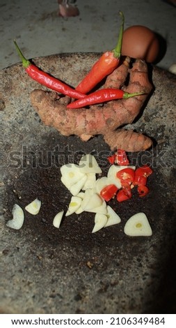Slices of chili and garlic for cooking spices are placed on a stone mortar.