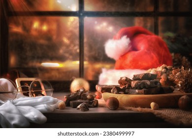 Slices of chocolate with hazelnuts on wooden windowsill with santa claus dress and window behind with dark christmas street. Front view. - Powered by Shutterstock