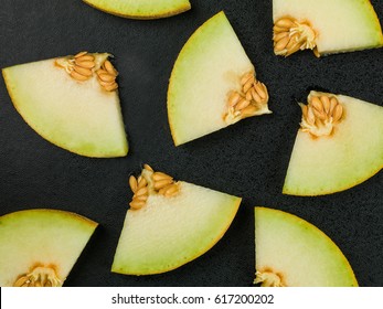 Slices Or Chunks Of Honeydew Melon On A Black Background