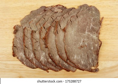 Slices Of Cold Roast Beef On A Wooden Board