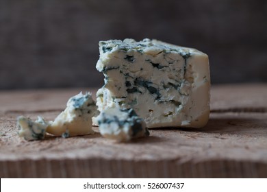Slices of Danish Blue cheese on an old wooden table, selective focus