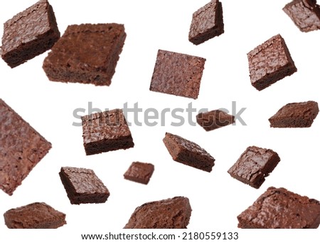 Slices of delicious chocolate brownie flying on white background