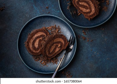 slices of delicious chocolate roll cake on blue plate, top view - Shutterstock ID 1657380064